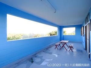 a blue room with a table and two windows at Kokumin Shukusha Sun Marina in Kaminato