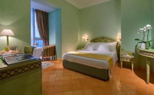 a hotel room with a bed and a table and a window at Miramare E Castello in Ischia