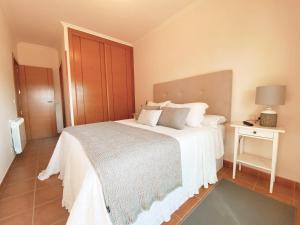 sypialnia z białym łóżkiem i stolikiem nocnym w obiekcie APARTAMENTO ANTOPA MAR w mieście Sanxenxo