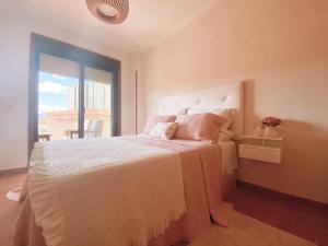 sypialnia z białym łóżkiem i oknem w obiekcie APARTAMENTO ANTOPA MAR w mieście Sanxenxo