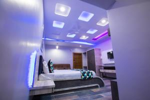 a bedroom with a bed and a purple ceiling at Hotel Balaji Palace in Porbandar