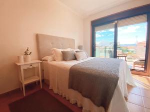 sypialnia z łóżkiem i dużym oknem w obiekcie APARTAMENTO ANTOPA MAR w mieście Sanxenxo