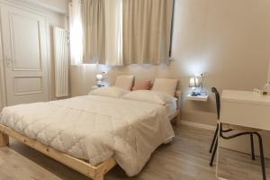 um quarto com uma cama com lençóis brancos e uma janela em Corte castella em Mantova