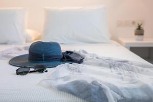 a hat and sunglasses sitting on top of a bed at Hotel Sunshine in Kamari