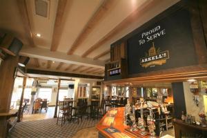 a bar in a restaurant with a large sign on the wall at The Tawny Owl in Swindon