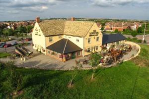 an aerial view of a large yellow house with a roof at The Tawny Owl in Swindon