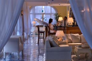 a man and a woman standing in a living room at Miramare E Castello in Ischia