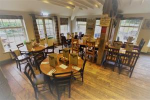 a restaurant with wooden tables and chairs and windows at The Tawny Owl in Swindon