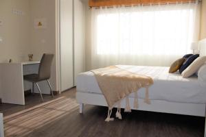 a bedroom with a bed and a desk and a window at Hotel La Terraza in Miño