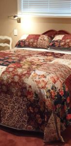 a bedroom with two beds with a floral bedspread at Matai Huka Boutique Accommodation in Paraparaumu