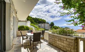 a patio with a table and chairs on a balcony at Villa Lenka and Mate Ivanac in Brela