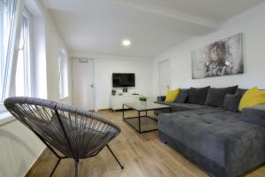 uma sala de estar com um sofá e uma cadeira em St.Sava apartment em Belgrado