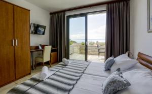a bedroom with a bed with a view of the ocean at Villa Lenka and Mate Ivanac in Brela