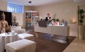 a man is standing behind a counter in a salon at Miramare E Castello in Ischia