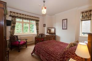 een slaapkamer met een bed, een stoel en een raam bij Ardwyn House in Llanwrtyd Wells