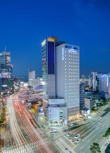 Toyoko Inn Seoul Dongdaemun II في سول: أفق المدينة مع حركة المرور على الطريق السريع المزدحم