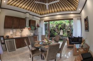 eine Küche und ein Wohnzimmer mit einem Tisch und Stühlen in der Unterkunft Villa Barong in Candidasa