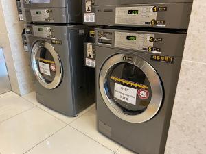 três máquinas de lavar roupa sentadas uma ao lado da outra num quarto em Toyoko Inn Seoul Dongdaemun II em Seul