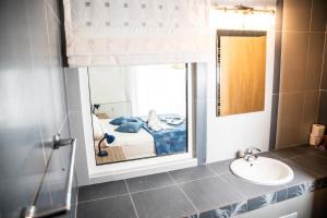 baño con lavabo, cama y espejo en Club Onix Apartments, en Neptun