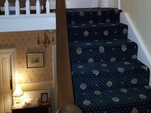 a staircase in a room with a blue patterned stair case at Crescent Lodge Guest House in Whitby