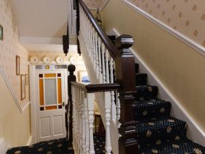 una escalera en una casa con escaleras blancas y marrones en Crescent Lodge Guest House, en Whitby