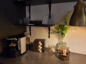 a table with a lamp and a vase with a plant at 4B Österlen Bed & Breakfast in Tomelilla