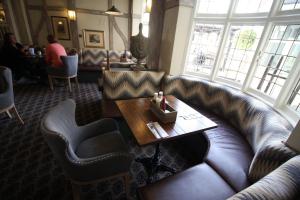 a living room with a leather couch and a table at The White Hart in Whitchurch