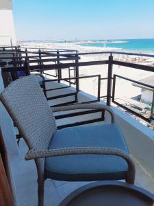 a chair sitting on a balcony overlooking the beach at Vila Adriano pe plaja Belona in Eforie Nord