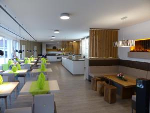 um restaurante com mesas e cadeiras e uma cozinha em Grüner Baum em Külsheim