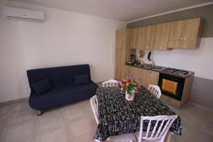 a living room with a table and a blue couch at Chiaro di Luna in Santa Domenica