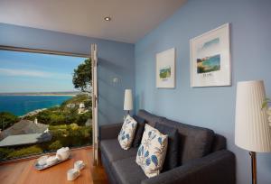 a living room with a couch and a large window at The View in Carbis Bay