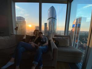 モスクワにあるСамый высокий отель в Европе с лучшим видом на Москву - Say Wow Capsule Hotelの窓の前のソファに座る二人の女性