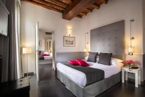 a bedroom with a large bed with red pillows at Stay Inn Rome Via Del Corso in Rome