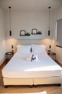 een wit bed in een slaapkamer met twee foto's aan de muur bij Urban Sea View Lofts #2 in Chalkida