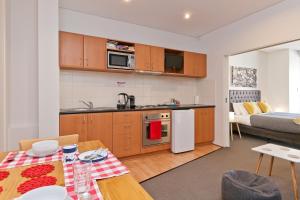 eine Küche und ein Wohnzimmer mit einem Tisch in der Unterkunft Central City Exclusive Apartments in Perth