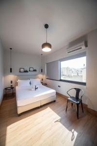 Un dormitorio con una cama, una silla y una ventana en Urban Sea View Lofts #2, en Chalkida