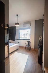 een slaapkamer met een bed, een stoel en een raam bij Urban Sea View Lofts #2 in Chalkida