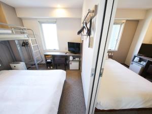 a hospital room with two beds and a desk at Super Hotel Tokyo Nihombashi Mitsukoshimae in Tokyo