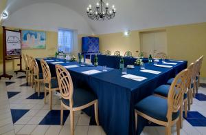 a long blue table with chairs in a room at Miramare E Castello in Ischia