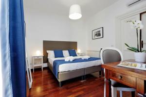 a bedroom with a blue and white bed and a desk at Midnight in Rome Guest House in Rome