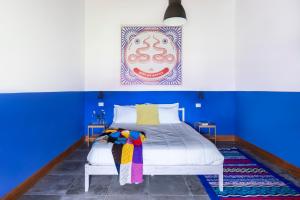 a bedroom with blue walls and a white bed at Agriturismo Braciami in Viterbo