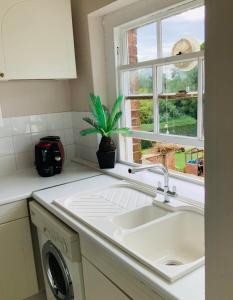 a white kitchen with a sink and a window at The Stables Apartment in Newark-on-Trent