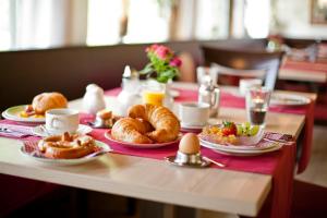 a table with croissants and pastries and eggs on it at Würmtaler Gästehaus in Munich