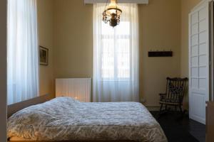 a bedroom with a bed and a window and a chandelier at Mora Valisi in Nafplio