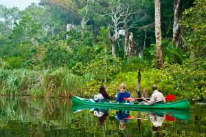 Drei Menschen in einem Kanu auf einem Fluss in der Unterkunft Kosi Forest Lodge in Manguzi