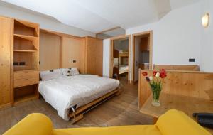 a bedroom with a bed and a table with flowers at Residence Miramonti in Daiano