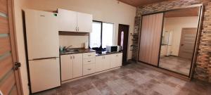 a kitchen with white cabinets and a sink and a mirror at RestTime Апартаменты in Zatoka