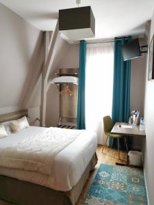 1 dormitorio con cama, escritorio y ventana en Hotel Eden, en Béthune