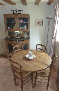 een houten tafel en stoelen in een kamer bij Pergoloire in La Bohalle