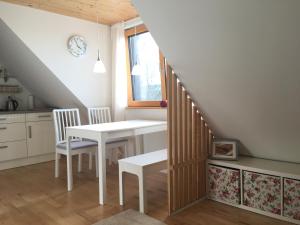 a white table and chairs in a kitchen with a staircase at Ferienwohnung Kapellenweg Bambergen bei Überlingen in Bambergen +15 photos